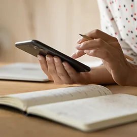 Woman using phone at table.